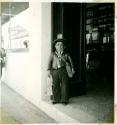 Scan of photograph from Judge Burt Cosgrove photo album.Midget selling lottery tickets