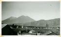 Scan of page from Judge Burt Cosgrove photo album. Across roof to fuego and Acatanango Fuego is smoking