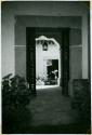 Scan of photograph from Judge Burt Cosgrove photo album.Through the arch into the dining room patio