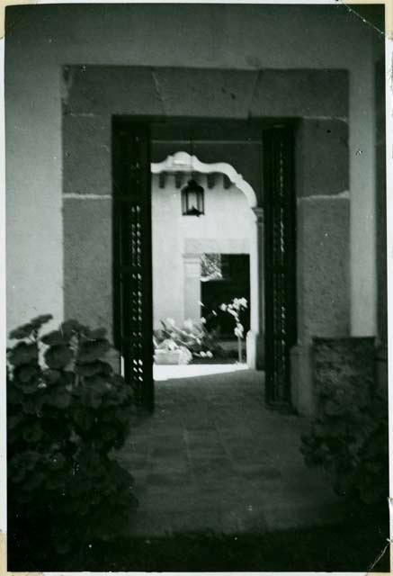 Scan of photograph from Judge Burt Cosgrove photo album.Through the arch into the dining room patio