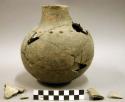 Ceramic partial vessel, mended, protrusions around base of neck, sherds inside v