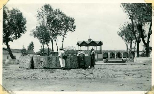 Scan of photograph from Judge Burt Cosgrove photo album.The pila in the plaza-municipal building at back