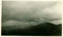 Scan of photograph from Judge Burt Cosgrove photo album. Laguna Mts.-Rain storm-Plane about 50 ft. under clouds.