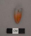 Ground stone; pendant; one side is flat, other side is faceted; loss at one end.