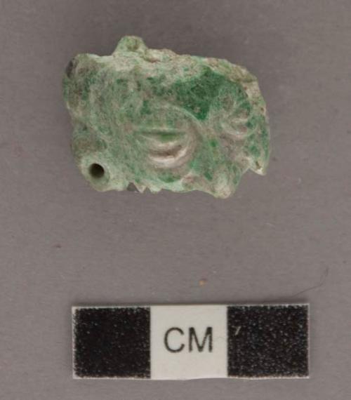 Portion of carved jadeite ornament, human face