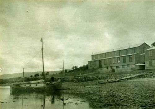 The "Kathleen" docked on the shore near the big house