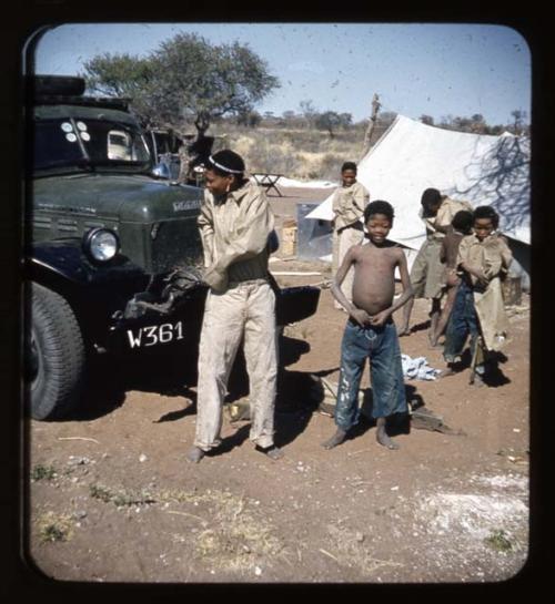 Expedition: Boys putting on Western clothing in front of an expedition truck, with a tent in the background