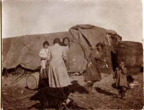 Inuit women and children in front of shelter