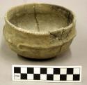 Ceramic bowl complete, puncatate at rim, scroll design on exteior surface, inter
