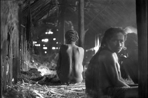 Samuel Putnam negatives, New Guinea. Inside a hunu at Abulupak; 2 old women; one with a child in her arms sits in the hunu