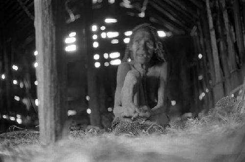 Samuel Putnam negatives, New Guinea. a woman gazes up at the ceiling in the hunu