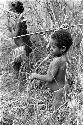 Samuel Putnam negatives, New Guinea. child raises a spear to throw it at the hoop