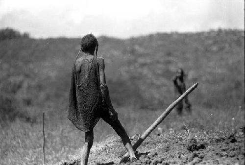 Samuel Putnam negatives, New Guinea. woman stands in fields; another woman in the background