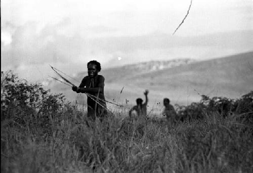 Samuel Putnam negatives, New Guinea; a man shoots some arrows