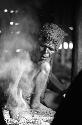 Samuel Putnam negatives, New Guinea; an old woman doing something with the fire