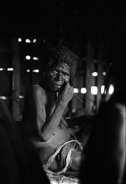 Samuel Putnam negatives, New Guinea;old woman picks her teeth with a piece of grass