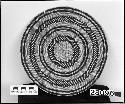 Circular basket mat or tray with yellow and black grasses.