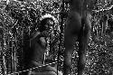 Samuel Putnam negatives, New Guinea; Tege Warek; talking to somebody; fixing his spear