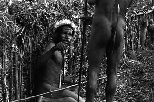 Samuel Putnam negatives, New Guinea; Tege Warek; talking to somebody; fixing his spear