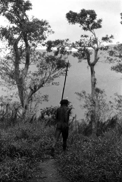 Samuel Putnam negatives, New Guinea; one warrior walking on the trail north past the Elokhere