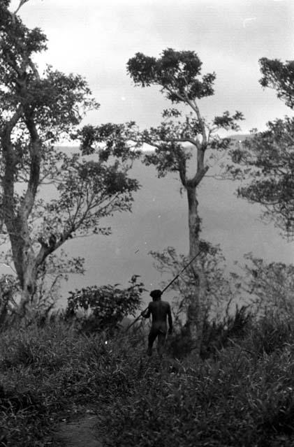 Samuel Putnam negatives, New Guinea; one warrior walking on the trail north past the Elokhere