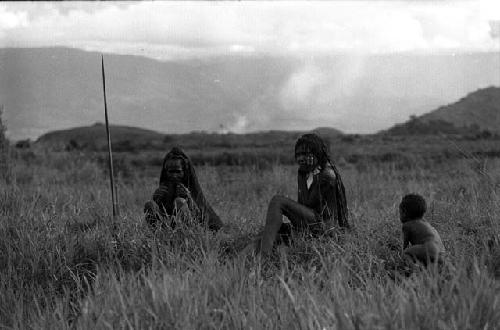 Samuel Putnam negatives, New Guinea; a woman waits beside Liberek watching; another woman and child near her