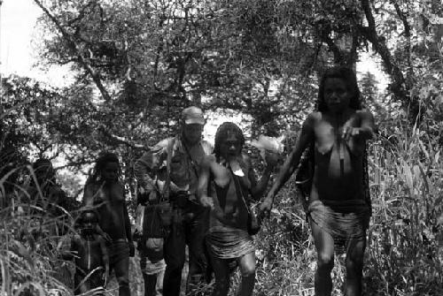 Samuel Putnam negatives, New Guinea; MR surrounded by women walking on a path towards the Etai in Kurelu area