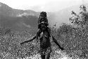 Samuel Putnam negatives, New Guinea; a woman walking with a child on her shoulders