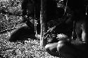 Samuel Putnam negatives, New Guinea; group of men knitting nyeraken are under an olea