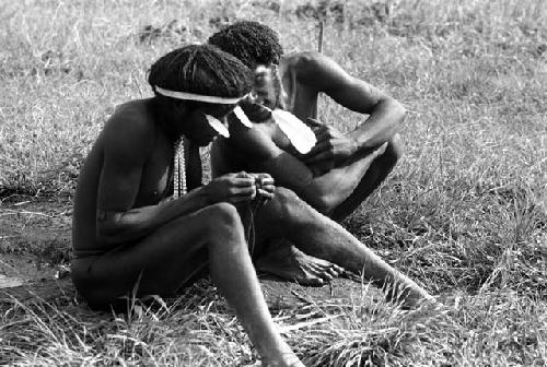 Samuel Putnam negatives, New Guinea; Walimo and another man inspect some walimoken strands