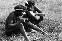 Samuel Putnam negatives, New Guinea; Walimo and another man inspect some walimoken strands