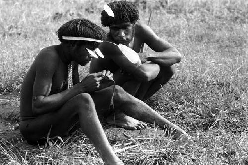 Samuel Putnam negatives, New Guinea; Walimo and another man inspect some walimoken strands