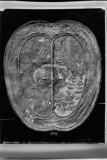 Photograph of a shield which belonged to King Philip II of Spain and is preserved in the Royal Army at Madrid. The entire surface is covered with feather-mosaic, and Mrs. Nuttall identifies this as of Mexican workmanship.