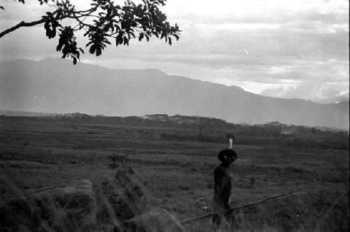 Samuel Putnam negatives, New Guinea; man walks past the rocks on Hellerabet