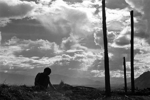 Samuel Putnam negatives, New Guinea; a boy against the skyline up with the partially finished structure where they gather wood