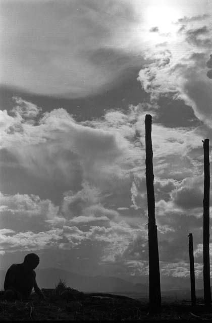 Samuel Putnam negatives, New Guinea; a boy against the skyline up with the partially finished structure where they gather wood