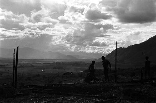 Samuel Putnam negatives, New Guinea; a boy against the skyline up with the partially finished structure where they gather wood