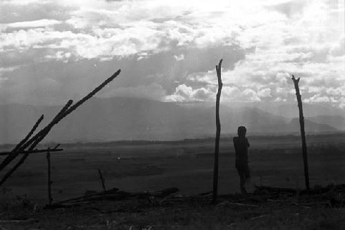 Samuel Putnam negatives, New Guinea; a boy against the skyline up with the partially finished structure where they gather wood