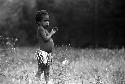 Samuel Putnam negatives, New Guinea; little girl in field; weeds; in front of her