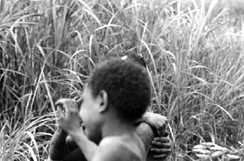 Samuel Putnam negatives, New Guinea; one boy in a mob of boys wrestling