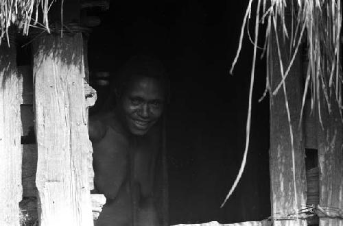 Samuel Putnam negatives, New Guinea; a woman looking out of the hunu at Abulupak