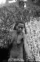 Samuel Putnam negatives, New Guinea; a woman outside of ebai in Abulupak; handing something to someone