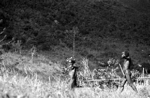 Samuel Putnam negatives, New Guinea; Wereklowe and 2 other men on their way out to their kaios; Wereklowe holds up his hand