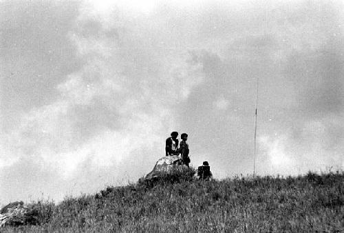 Samuel Putnam negatives, New Guinea; men seated on rocks on the Warabara waiting for the war to develop