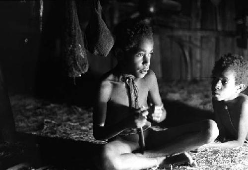 Samuel Putnam negatives, New Guinea; Uwar playing the picon; taken down from his mouth at the moment; Yege Abu looks at him