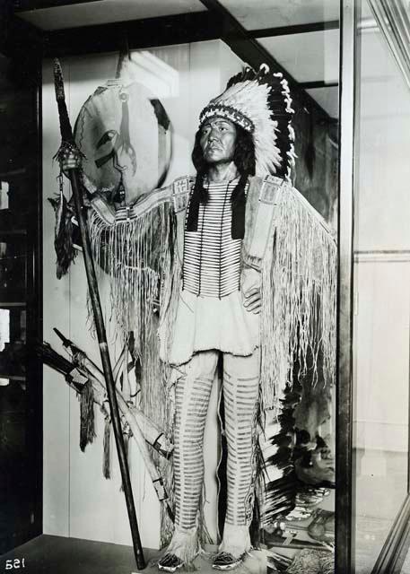 Model of Indian in eagle feather headgear, buckskin pants and shirt with tassels