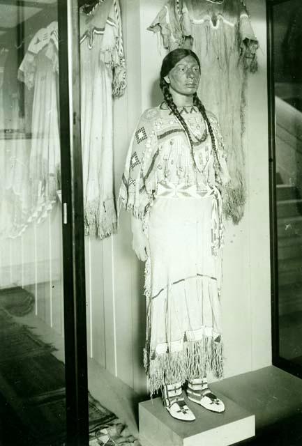 Indian woman (model) in complete native dress, including buckskin dress, legging