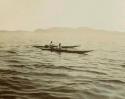 Two Greenland Inuit men paddling kayaks
