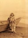 Inuit woman standing in front of a boat