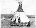 Man and woman in front of tepee